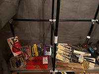 Overall lot showing utility cutters, boning knives, choppers, multi-tool hammer, and Sheffield multi-tool set arranged on shelving unit.
