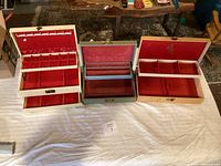 Lot of three antique jewelry boxes displayed open showing interior compartments and red fabric lining.