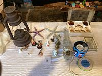 Full overview of assorted antiques and home decor items laid out on a white cloth
