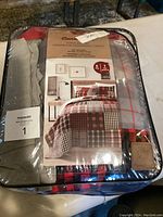 Packaged Canadiana bedding set with graphic showing plaid quilt on a bed and product information.