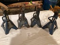 Four blue Certified brand jack stands on a white surface, showing front and side views with clear visibility of labels and handles.