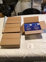 Six closed cardboard boxes and one open box showing two packs of Pencil Buddies Kids Triangular Pencils inside each pack containing 8 pencils.