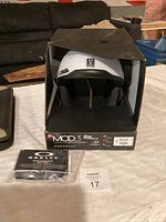 Front view of Oakley MOD3 helmet in original box with accessories.