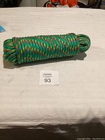 Front angle of coiled green braided rope with multicolor stitching.
