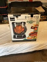 Box front showing Cuisinart VertiGenius Vertical Rotisserie with chicken inside.