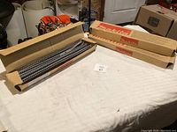 Three cardboard boxes of Makita drywall screws arranged on a table, one box opened showing the collated screws inside.