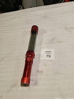 Full view of the red Snap-on battery operated work light with LED bulbs and transparent midsection.