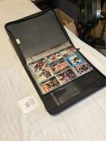 Photo of binder open on bed showing sports cards in plastic sleeves.