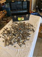 Overall view of toolbox with open lid and scattered chrome sockets on table