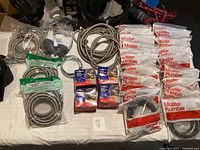 Overview of all items in the lot showing multiple sealed and loose washer and dryer hoses and components