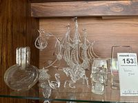 Photo showing blown glass ship with three masts, swan, unicorn, two square paperweights, and hanging glass bird basket