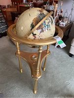 Full view of globe on brass tripod stand with compass visible at base