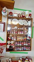 Overall display of Campbell's Soup collectibles in wooden display cabinet and surrounding shelves