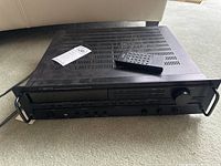 Full view of Carver HR-742 receiver on carpet with remote on top and tag showing lot info