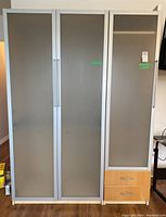 Front view showing both wardrobe sections; larger two-door section on left and smaller one-door section with two drawers below on right.