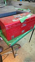 Red Craftsman steel toolbox closed, showing top handle and wear