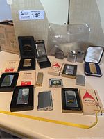 Overview of lot on table showing boxed and unboxed lighters and parts bag