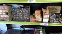 Wide view of multiple small drawers filled with hardware parts and various boxes including a Weiser lock setting kit box on a shelf