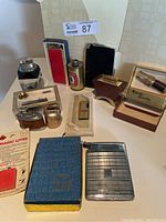 Overview image showing the collection of vintage lighters and one boxed pipetriter on a white table