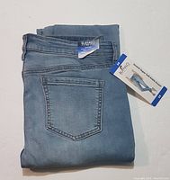 Folded light blue Buffalo David Bitton women's jeans showing back pocket and waistband with brand label and size tag.