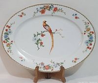 Full front view of the oval porcelain platter showing the golden pheasant and floral decoration with gold edge trim.