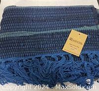 Photo of hand woven blue rug showing woven detail, texture, and color variations with a Rivonola brand tag.