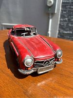 Front angle view of the red metal 1954 Mercedes-Benz model showing detailed grille, headlights, and hood area.
