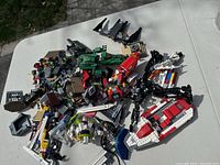 Photo of assorted Lego pieces scattered on a table showing various pieces including vehicles and mechanical parts