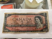 Photo of the front of the Canadian two dollar note, showing entire note with serial number and portrait in view.