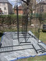 Overview of five metal grid panels assembled with T-shaped base stands on tarp