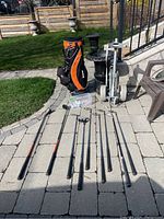 All golf clubs arranged on ground beside golf bag and metal cart