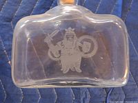 Photo of a clear glass container showing etched image of a Viking with sword and shield.