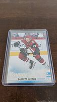 Front side of the Barrett Hayton Young Guns Rookie card featuring the player skating in Arizona Coyotes uniform.