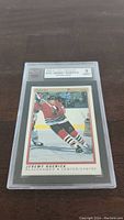 Front view of one 1990 Jeremy Roenick rookie hockey card in protective plastic casing, graded KSA 9 mint condition.