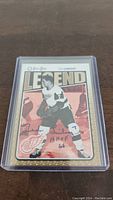 Front of the Ted Lindsay O-Pee-Chee Legend hockey card, signed by Ted Lindsay with inscription "HOF 5 66". Card is inside a hard plastic protective case.