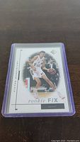 Front of Victor Wembanyama rookie card, shows player in white basketball uniform in action, Rookie Fix insert, serial numbered 1/99