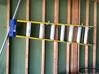 Full side view of the Davidson aluminum ladder mounted on wall studs showing length and yellow side rails.
