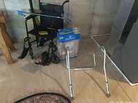 Wheelchair, toilet rail, bath seat box visible in background, along with grabber tool on the wheelchair seat