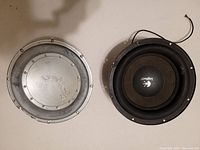 Front view of the two 10-inch subwoofers, one showing the Logitech branded cone and the other showing the back metal casing.