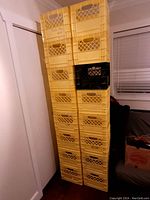 Stacked yellow plastic milk crates with one black crate included, showing overall lot quantity and colors.