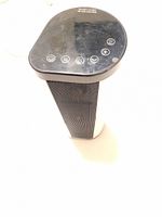 Front angle showing black touch control panel on top and black vent grid on white cylindrical body