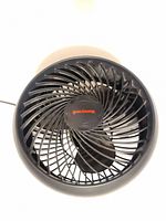 Front view of Honeywell fan showing black spiral grille and blades with cental red Honeywell logo.