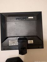 Rear view of the Philips monitor showing the logo, mounting area, and product labels with specifications.