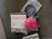 7 ft x 10 ft drop sheet in packaging with pink microfiber cleaning pad and black circular sealed item on top