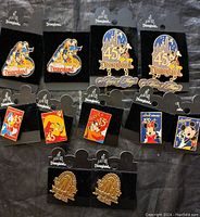 Photo showing 11 Disney collectible pins on their display cards, featuring Disneyland and 45th anniversary themes.