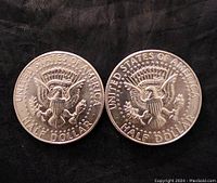 Reverse sides of both Morgan dollars showing heraldic eagle design and 'UNITED STATES OF AMERICA – HALF DOLLAR' legend