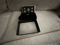 Opened black presentation box with display of proof coins