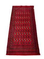 Full view of red Turkmen backrest rug with repeating diamond-shaped gul motifs and multiple patterned borders
