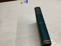Spine of book titled The Common Moths of England by J.W. Tutt, hardcover with green cover and gold embossed lettering, published by Routledge.