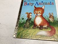 Front cover of the book showing a fox kit, squirrel, and rabbit with the title 'Baby Animals' and 'A Little Golden Book'.